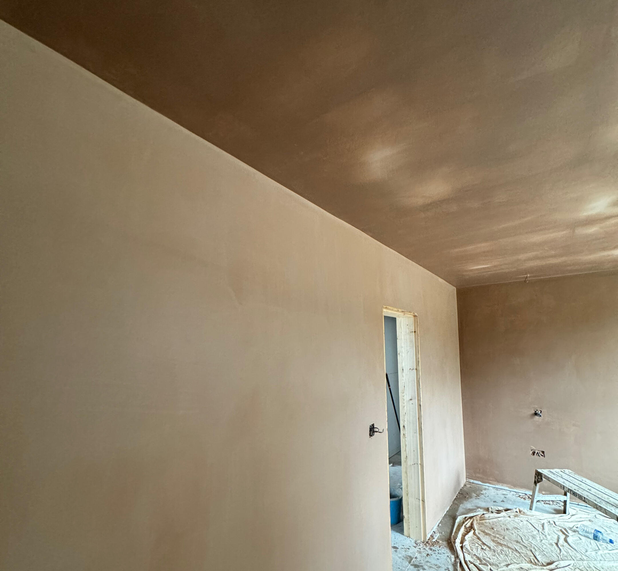 Freshly plastered walls and ceiling with protected flooring during a Gold Standard project